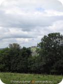 SX16174 Carreg Cennen Castle on top of distant cliffs seen through trees.jpg