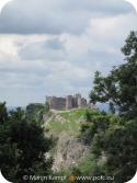 SX16175 Carreg Cennen Castle on top of distant cliffs seen through trees.jpg